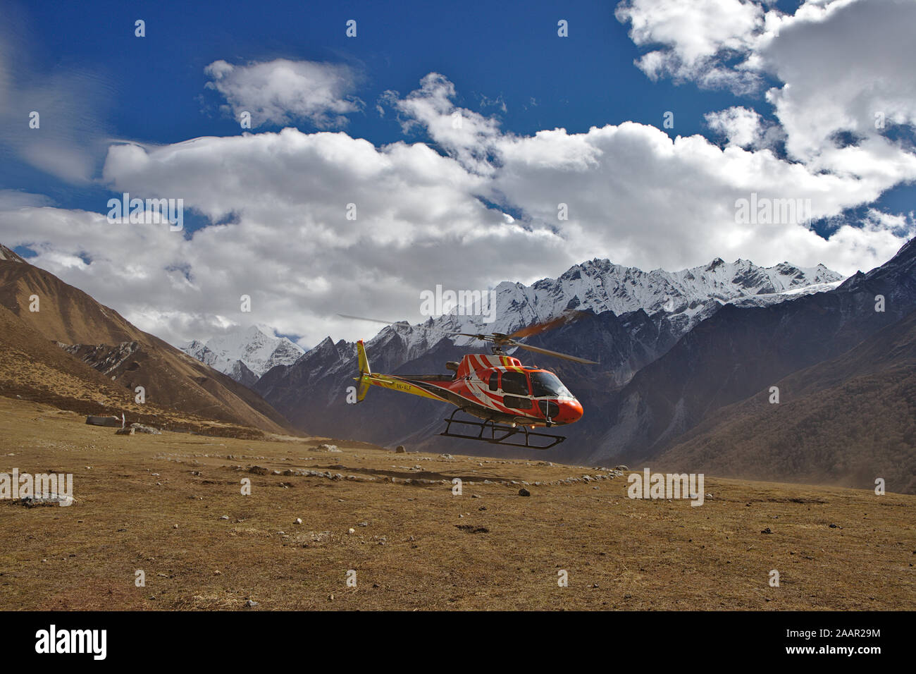 Rosso e giallo proveniente in elicottero a terra in Kyanjin Gompa Foto Stock