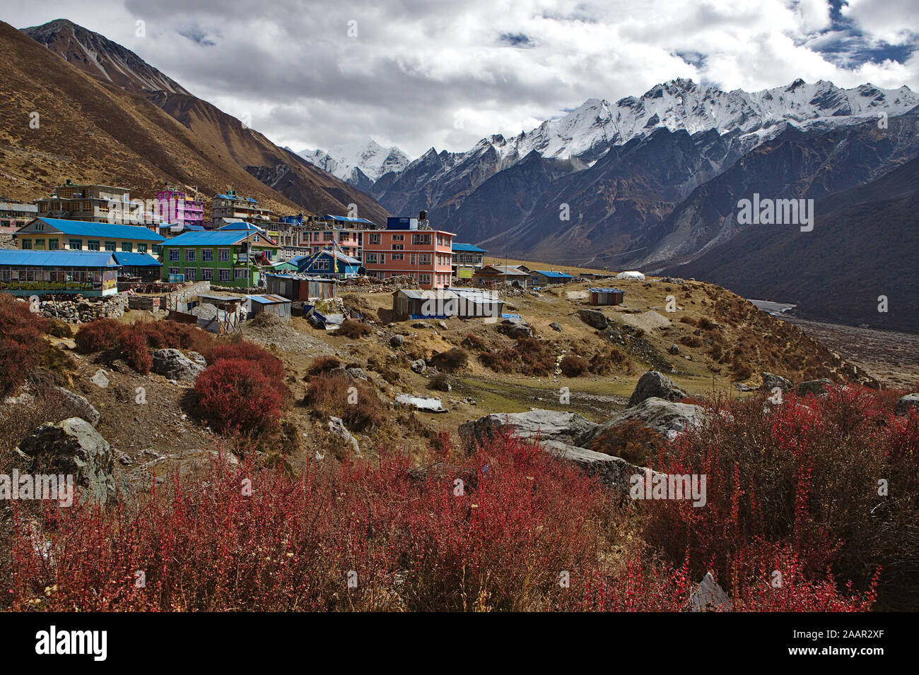 Vista di una piccola città Kyanjin Gompa accoccolato tra le montagne della Valle di Langtang Foto Stock