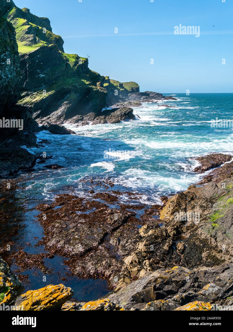 Scogliere sul mare, le onde e surf a Pig's Paradise,Isle di Colonsay, Scotland, Regno Unito Foto Stock