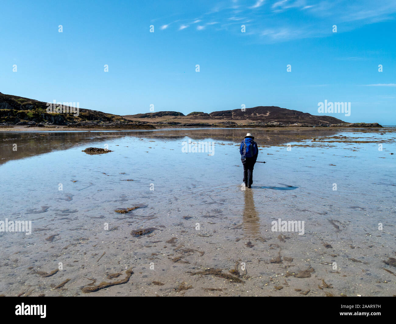 Turisti a piedi da Colonsay all'isola di marea di Oronsay attraverso il filamento, una spiaggia sabbiosa causeway tra le due isole delle Ebridi, Scotland, Regno Unito Foto Stock