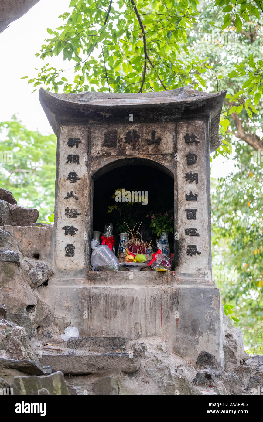 Un Santuario pieno di doni e offerte vicino al Jade tempio di montagna ad Hanoi, Vietnam Foto Stock