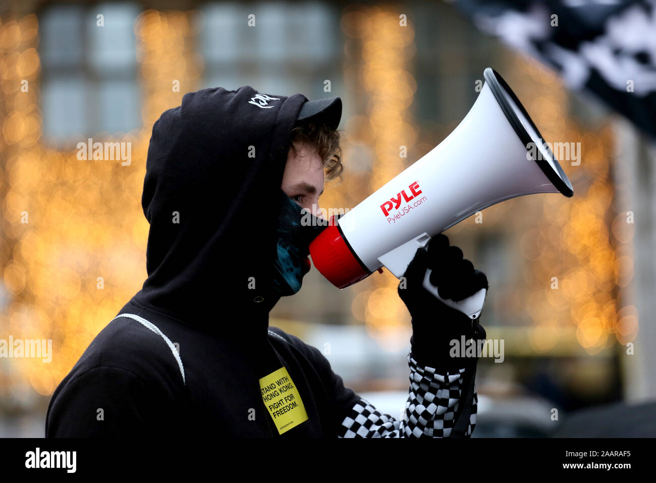 Manchester, Regno Unito. 23 Novembre, 2019. I manifestanti che mostra la solidarietà con Hong kongers che stanno vedendo dei disordini civili nel loro paese dopo la introduzione di una legge in materia di estradizione. Hong Kongers hanno 5 richiede la completa rimozione del Bill, ritiro di 'riot caratterizzazione' amnistia per i dimostranti arrestati, un'indagine polizia brutalità e attuazione di completare il suffragio universale. La protesta di solidarietà sono scesi in piazza in una marcia attraverso la città di chiamata del centro sulla Gran Bretagna a 'tenere la Cina per la sua promessa". I manifestanti hanno marciato superato la trafficata Mercatini di Natale distribuendo leaf Foto Stock