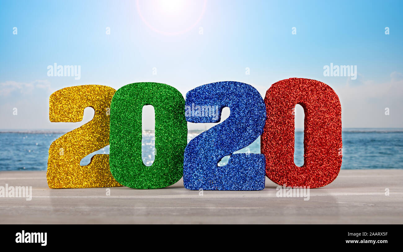 2020 Nuovo anni 3D i numeri su un tavolo con vista oceano e orizzonte in background. Foto Stock
