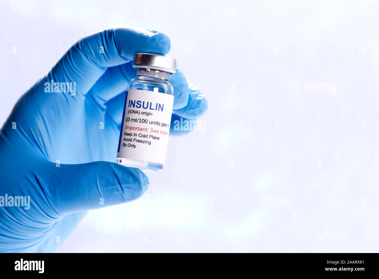 Insulina umana flaconcino tenuto dalla mano dell'operatore sanitario con copia spazio a destra. Foto Stock