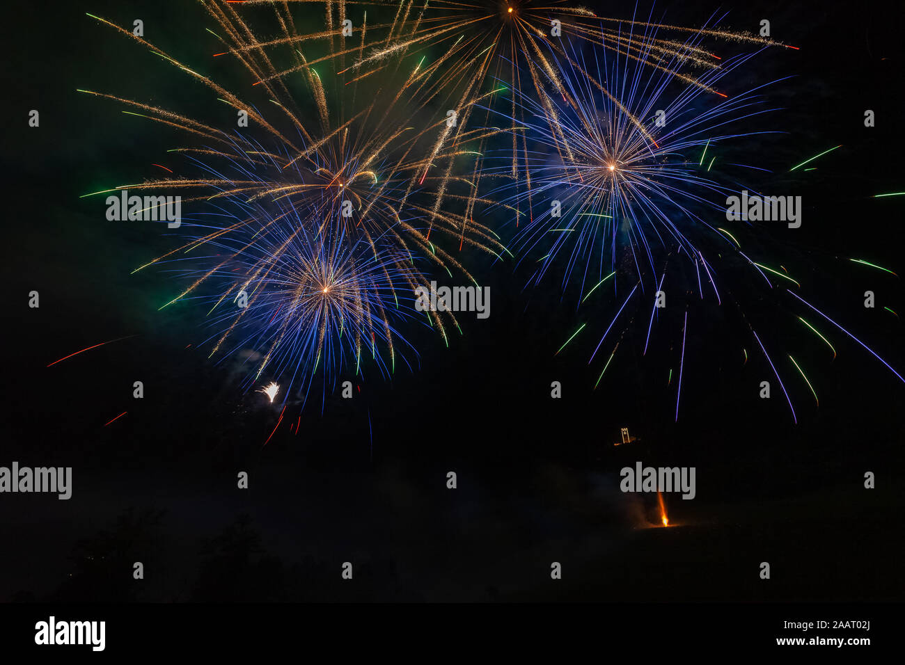 Blu e Oro esplosioni di fuochi d'artificio su una chiesa illuminata Foto Stock