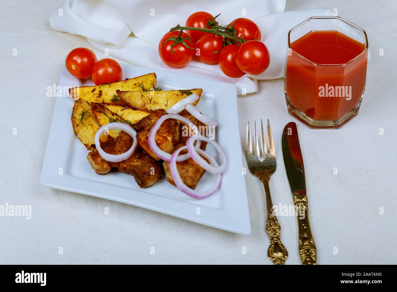 Carne arrosto di maiale con patate in una teglia da forno su un tavolo Foto Stock