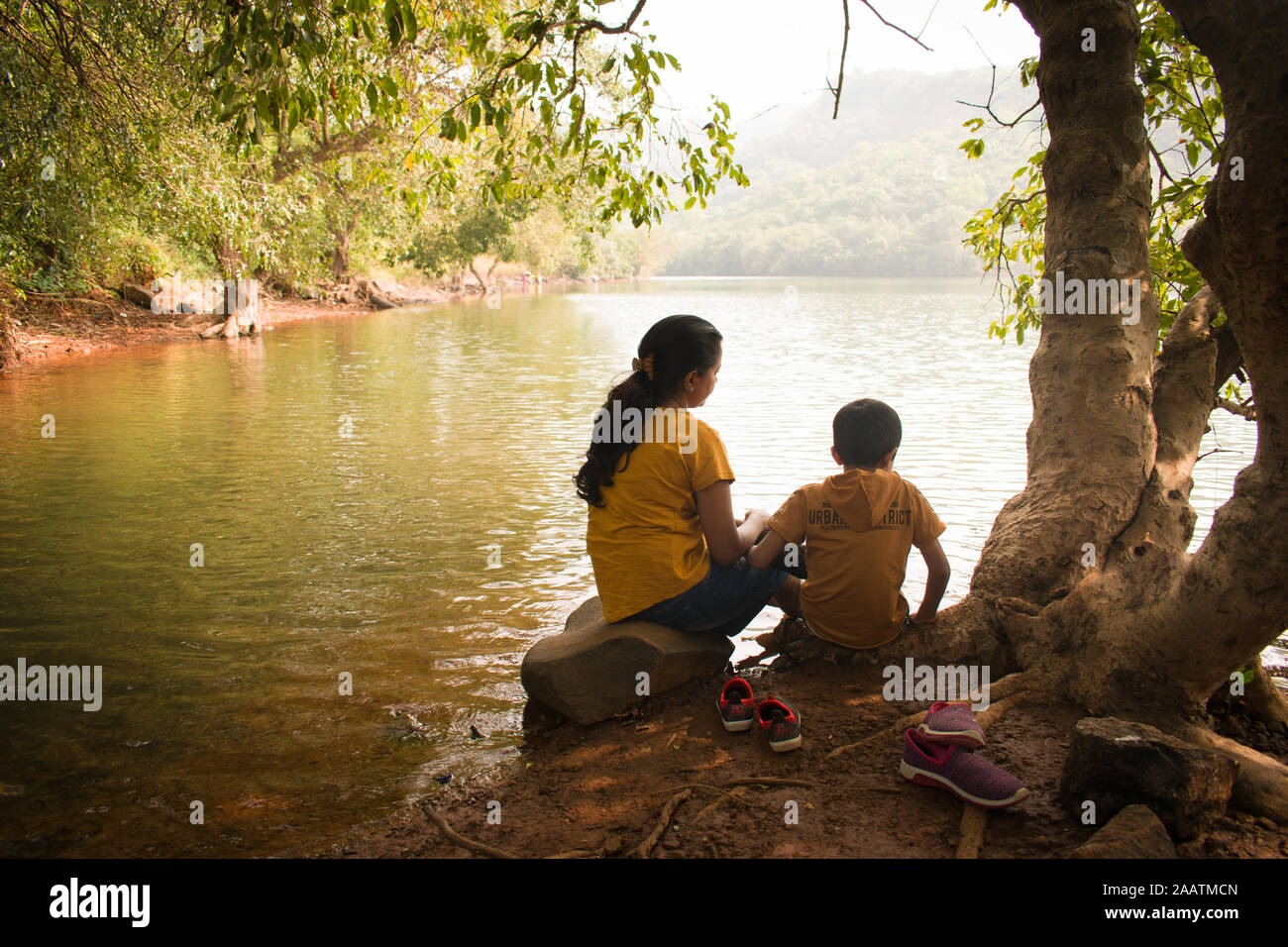 La madre e il Figlio seduto vicino a un lago e godersi la natura in un pomeriggio Foto Stock