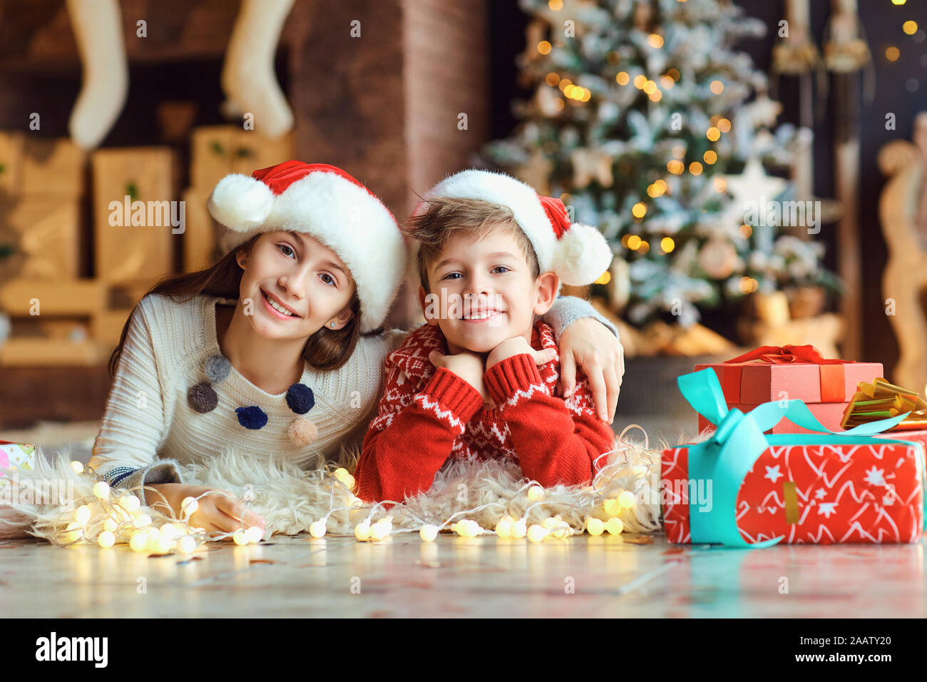 I bambini si trovano sul pavimento in Santa's cappelli sul Natale. Foto Stock