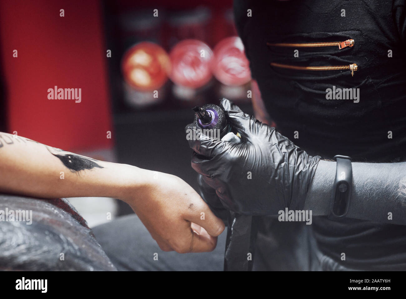 Close up tattoo machine. Master in nero Guanti sterili creazione di foto a portata di mano con esso in salone Foto Stock