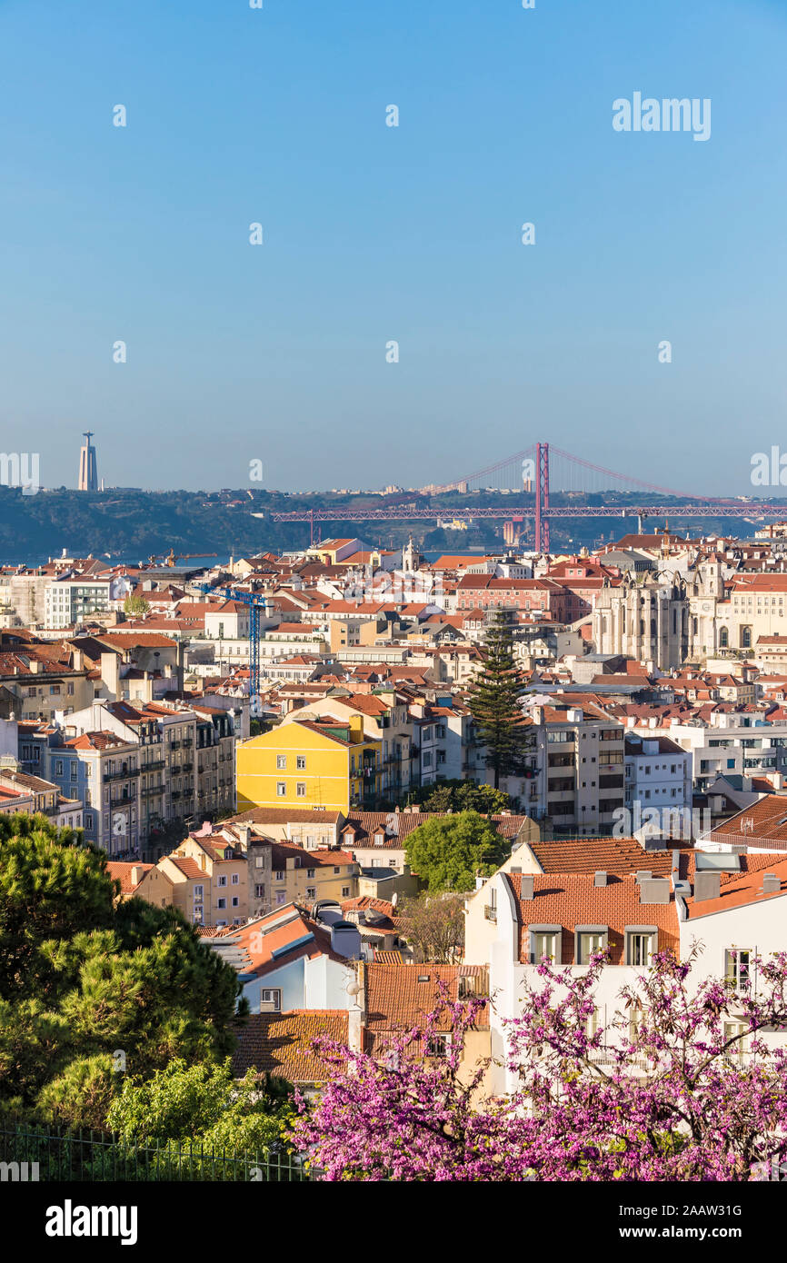 Edifici e 25 aprile ponte contro il cielo chiaro a Lisbona, Portogallo Foto Stock