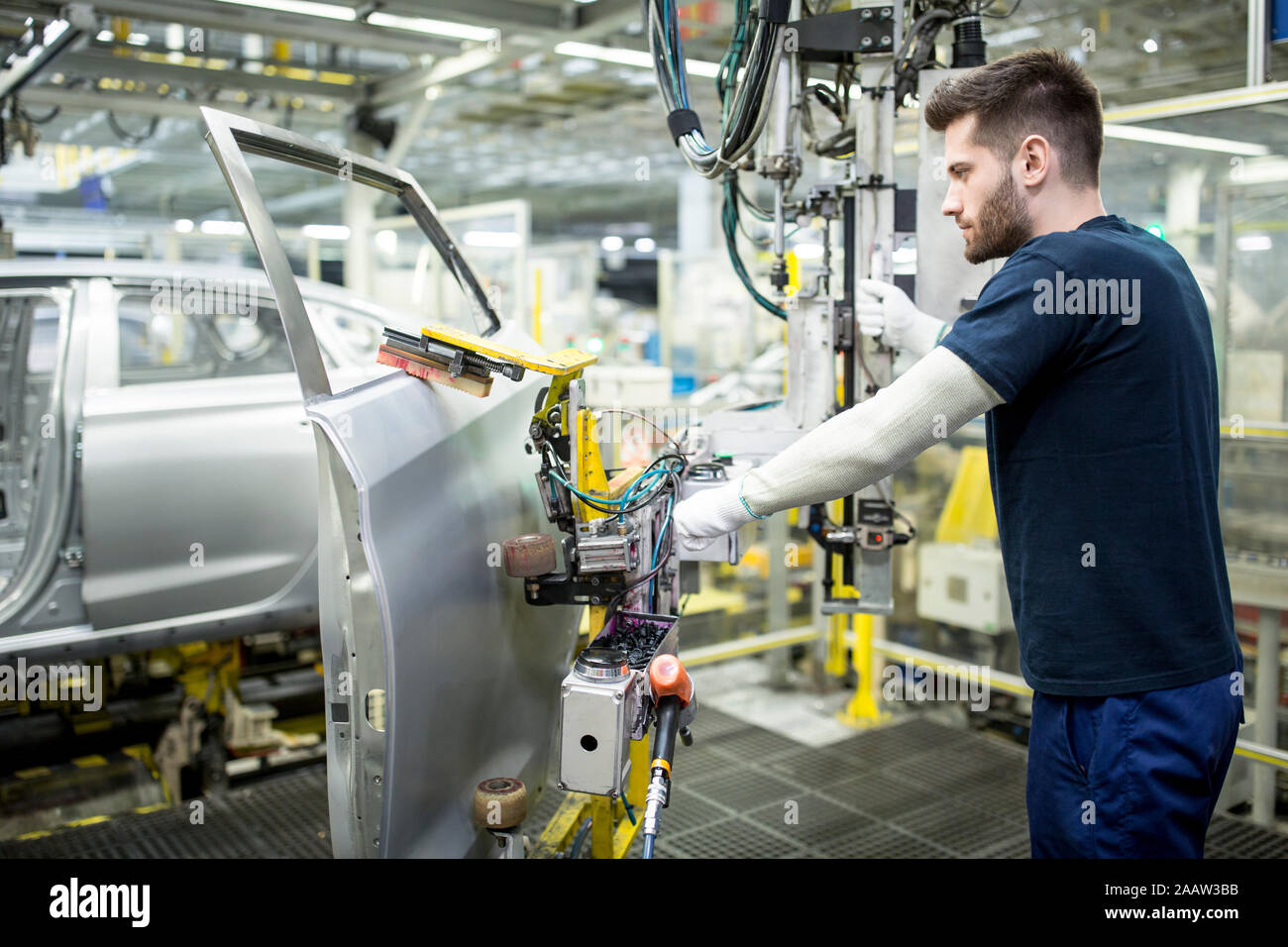 Uomo che lavora nella moderna fabbrica di automobili Foto Stock