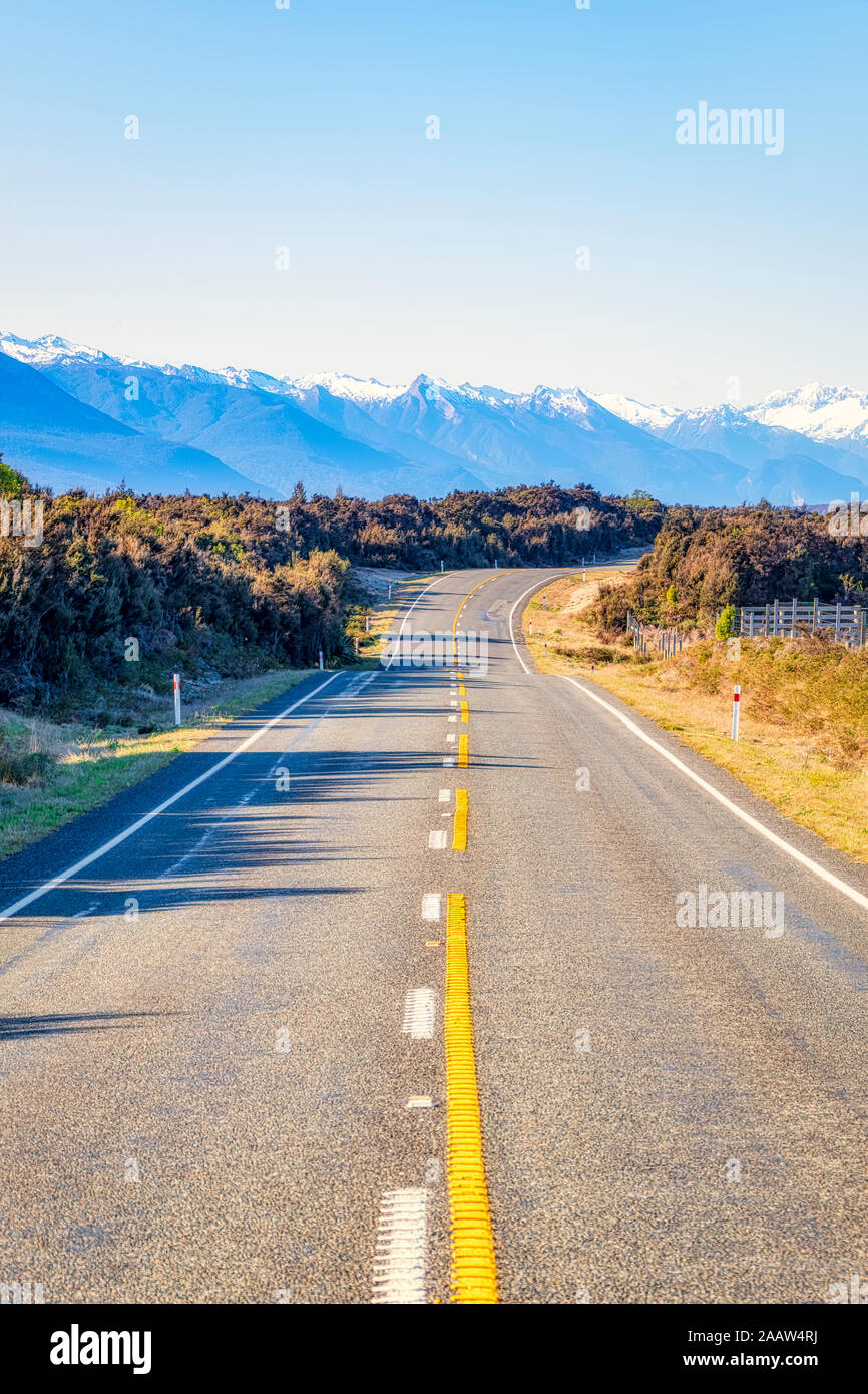 Vista la diminuzione della Statale 94 contro il cielo limpido, Te Anau, Isola del Sud, Nuova Zelanda Foto Stock