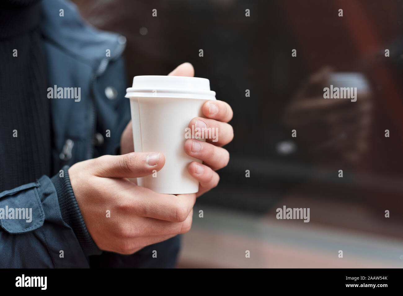 Giovane uomo tenendo un takeaway caffè all'aperto Foto Stock