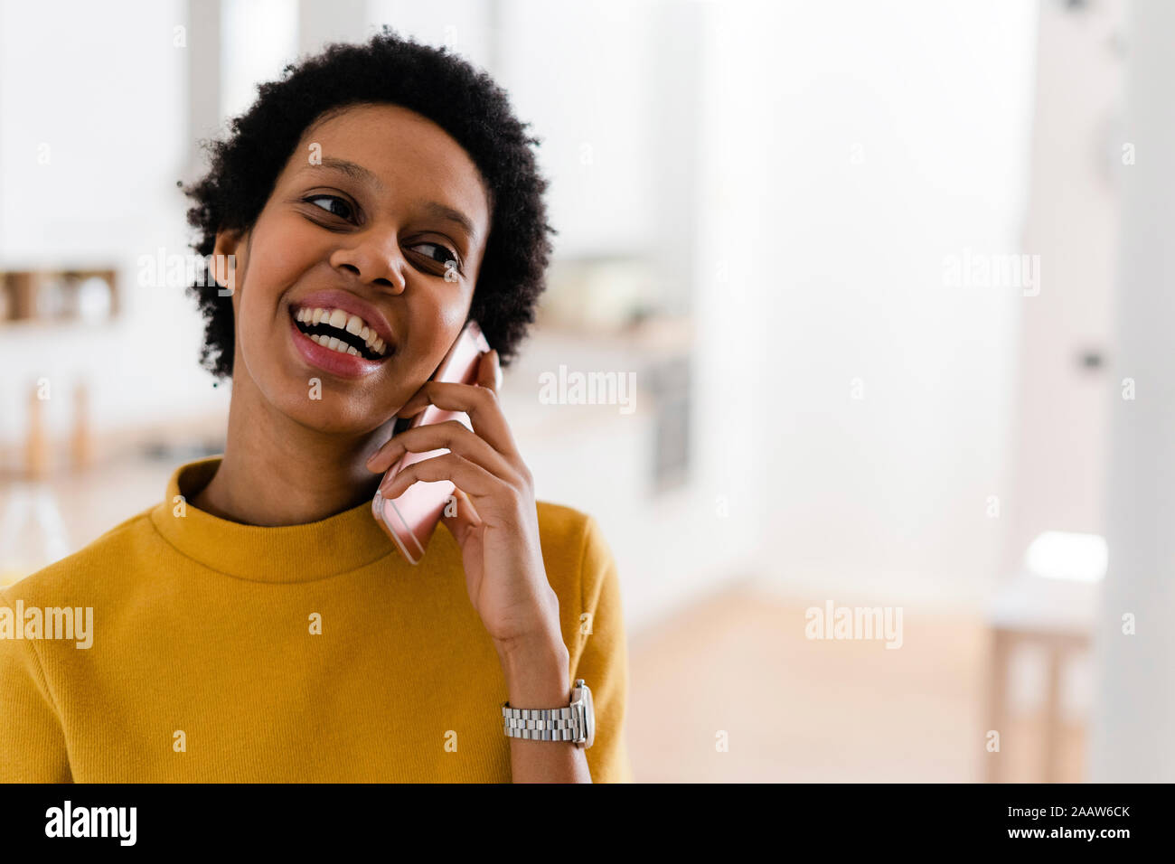 Felice giovane donna al telefono di casa Foto Stock
