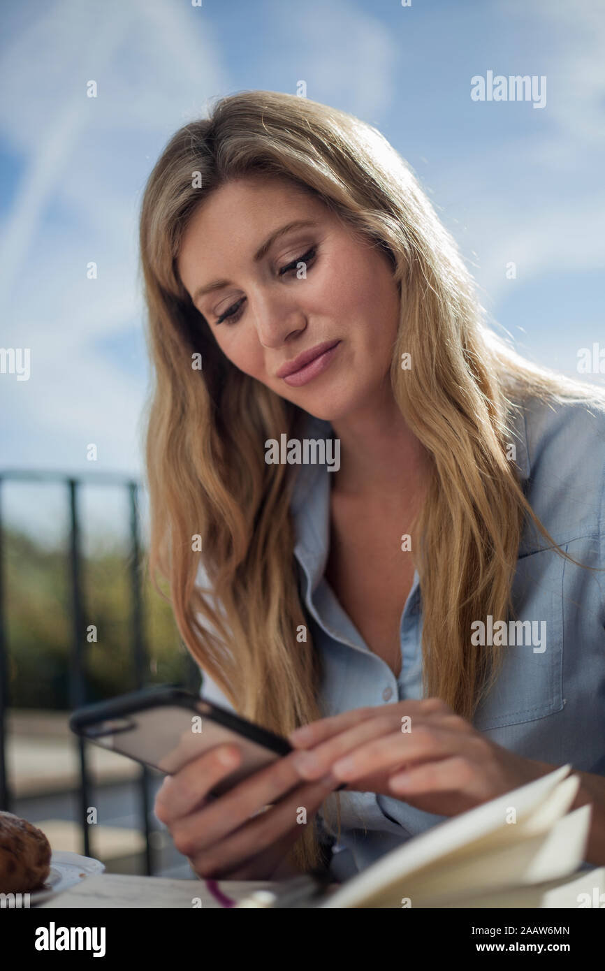 Donna texting vicino sul suo smartphone, all'aperto Foto Stock