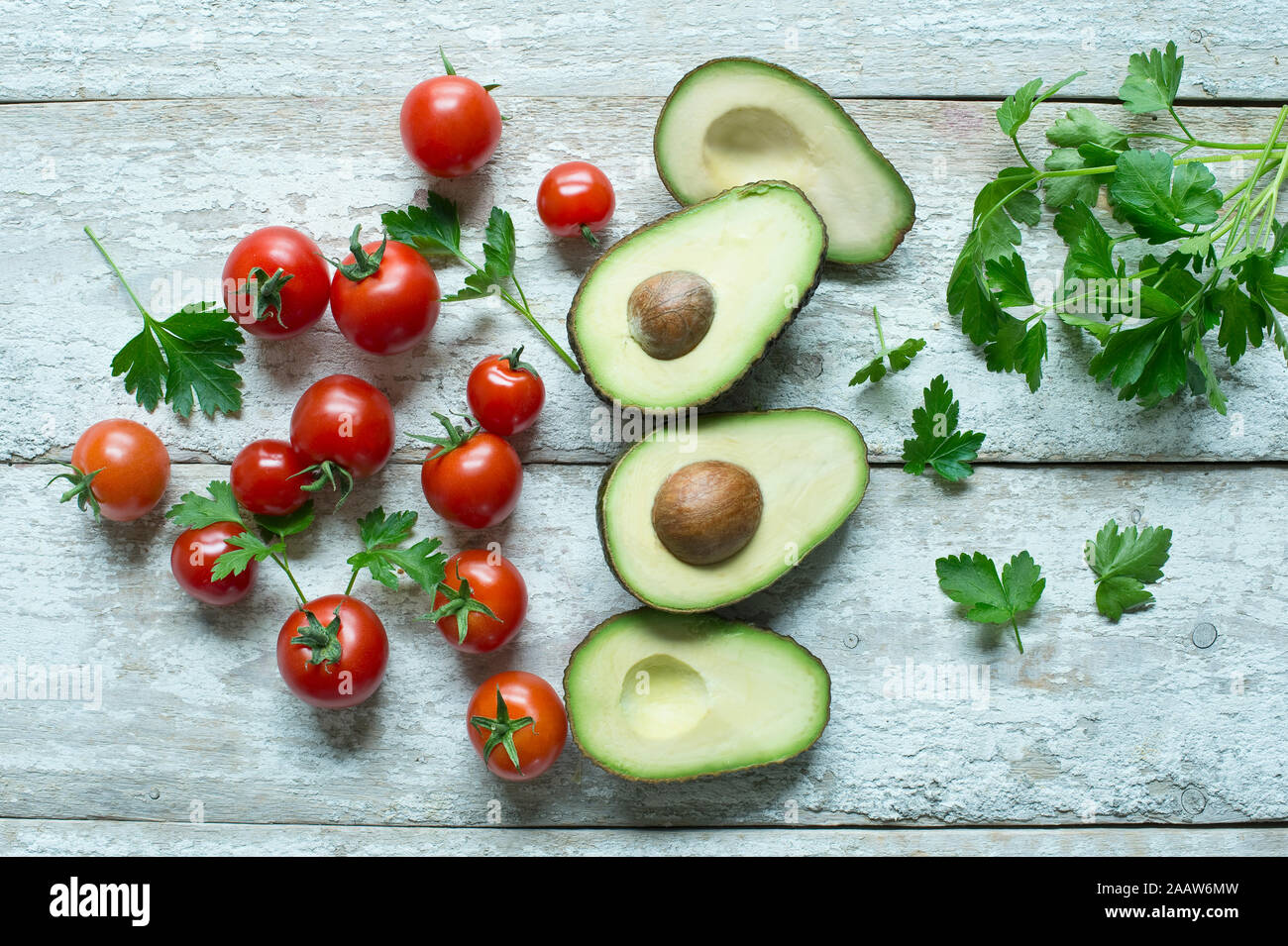 Direttamente sopra il colpo di avocado con pomodori e prezzemolo sul tavolo di legno Foto Stock