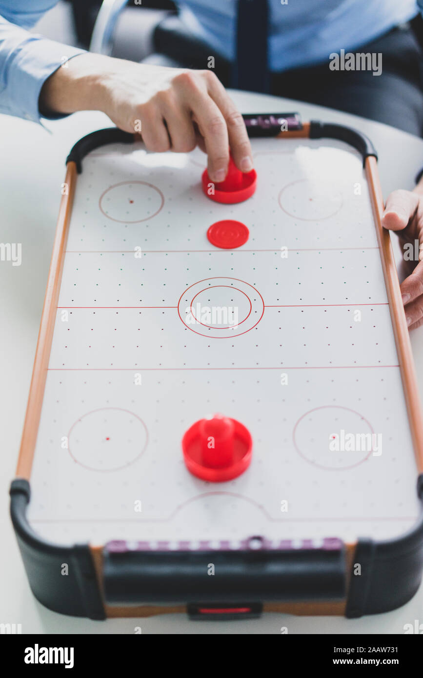 Close-up di imprenditore giocando air hockey Foto Stock