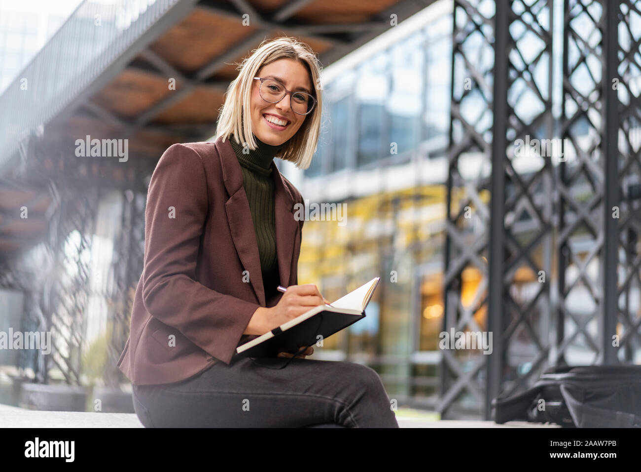 Ritratto di felice giovane imprenditrice con notebook in città Foto Stock