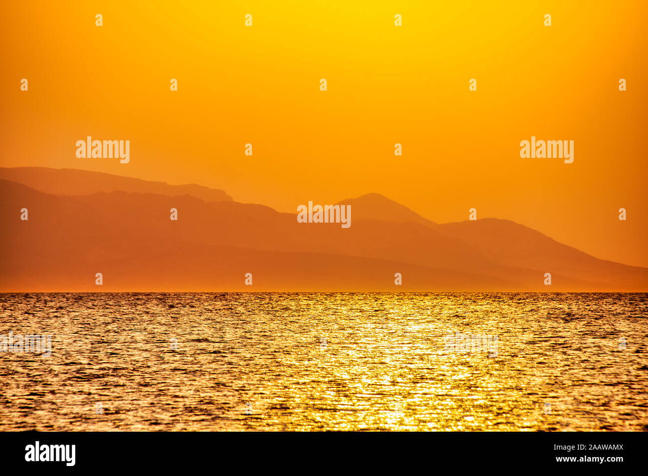 Colpo idilliaca isola di Rum contro arancione chiaro cielo durante il tramonto, Lochaber, Scotland, Regno Unito Foto Stock
