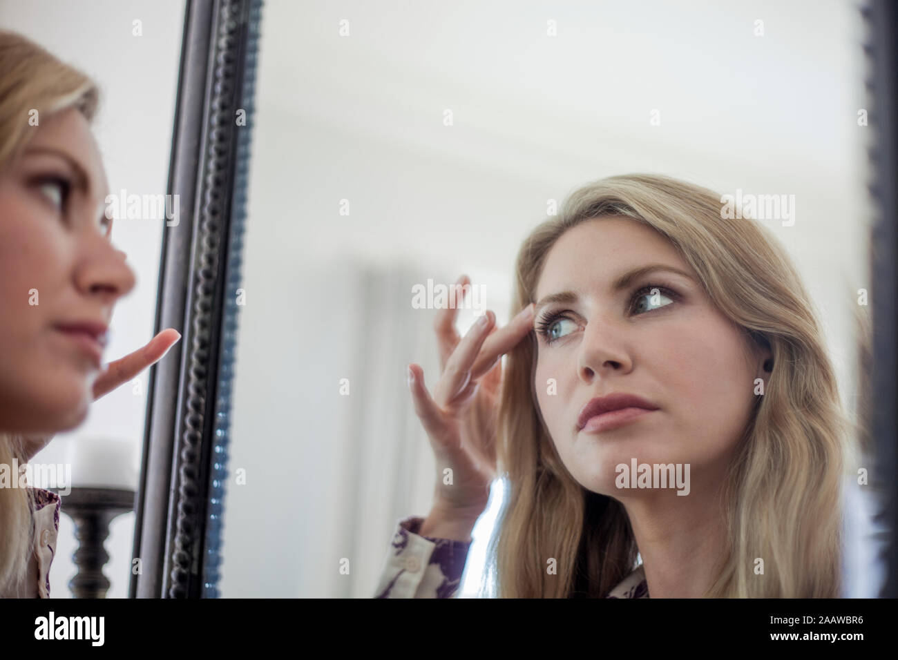 Donna controllo compongono in uno specchio Foto Stock