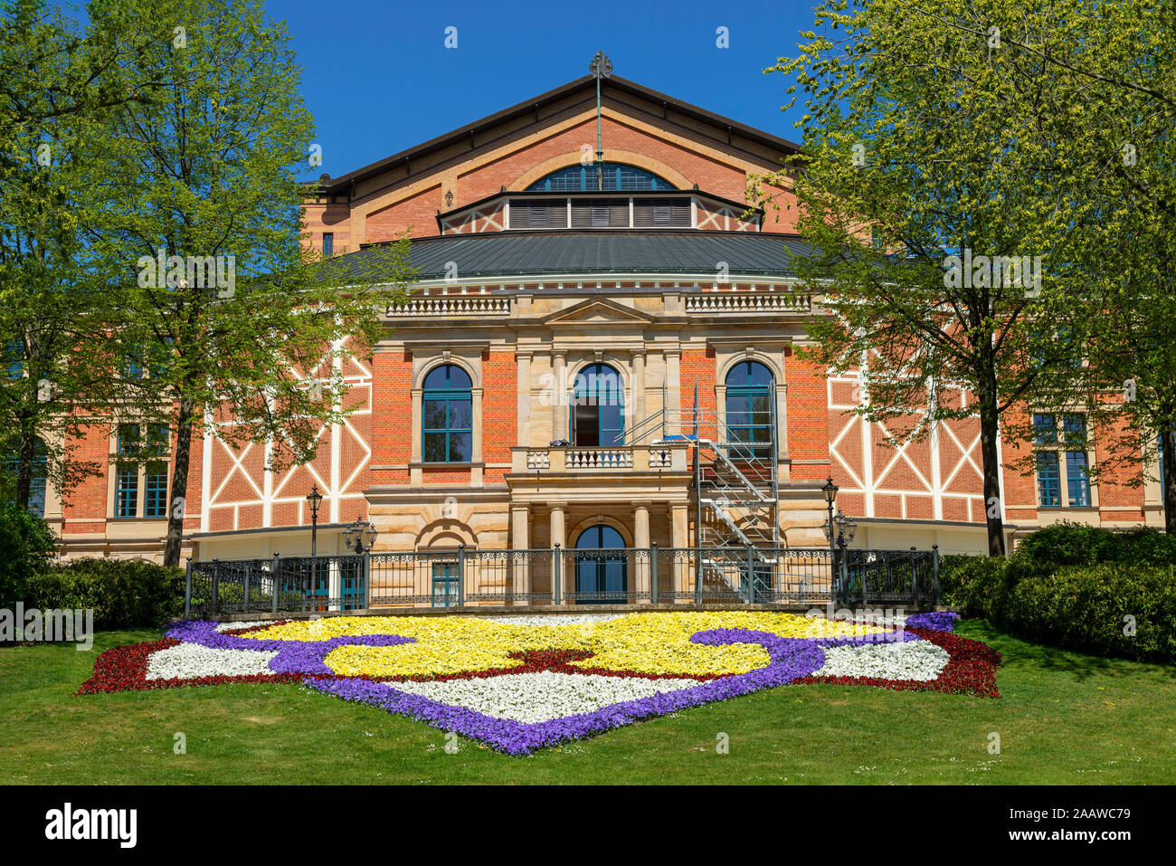 Fiori colorati crescente nella parte anteriore di Bayreuth Festspielhaus durante la giornata di sole, Bayreuth, Germania Foto Stock