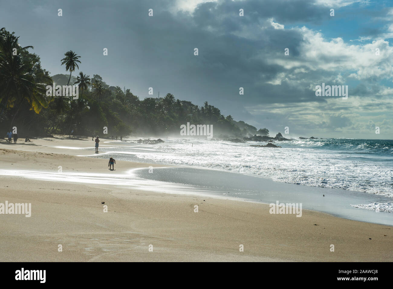 Vista panoramica di spruzzi delle onde a riva contro il cielo nuvoloso, Trinidad e Tobago, dei Caraibi Foto Stock