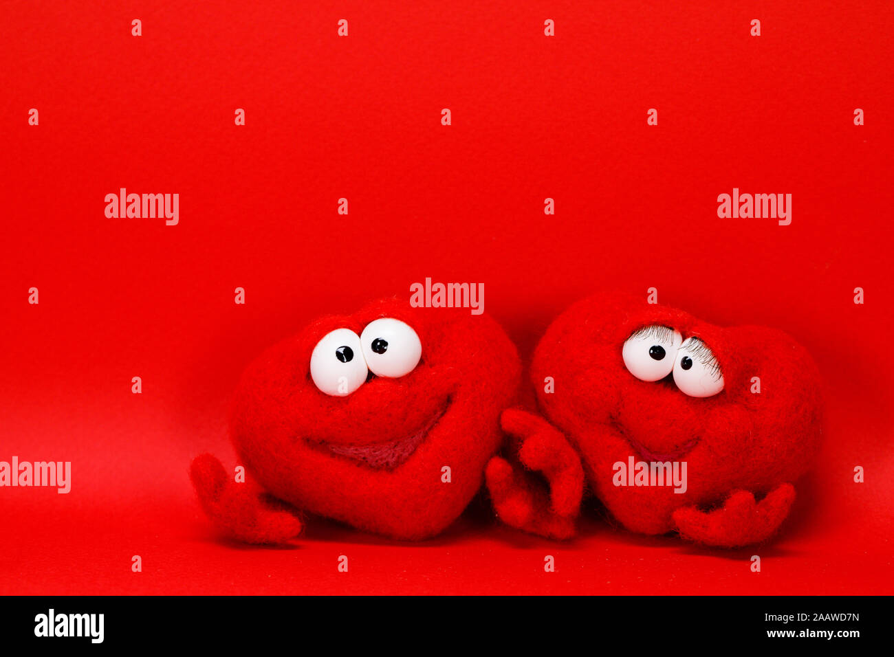 La lana di due cuori rossi su sfondo rosso con copia spazio per testo, simbolo dell amore, healtcare, san valentino di concetto Foto Stock