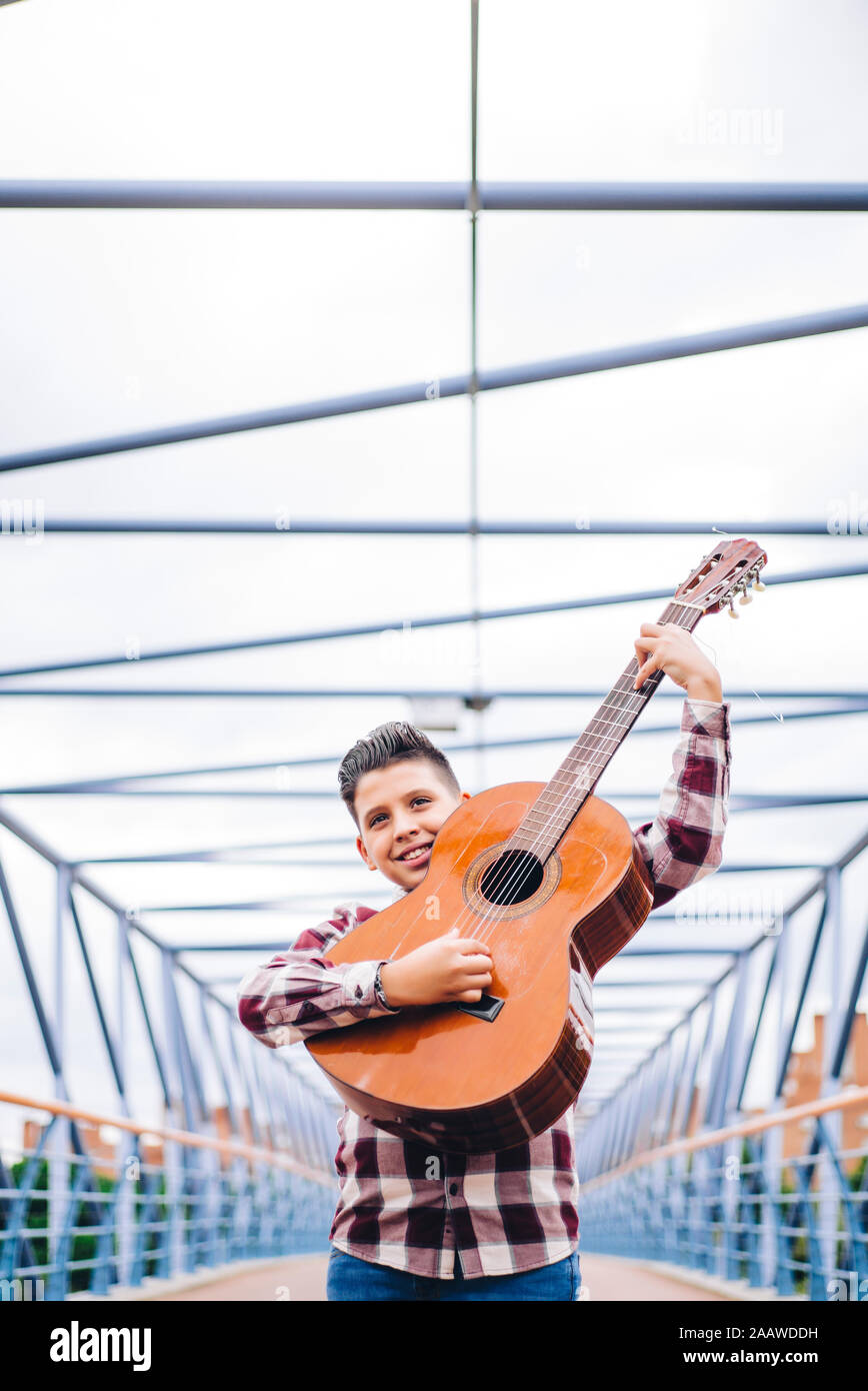 Gypsy boy a suonare la chitarra su un ponte Foto Stock