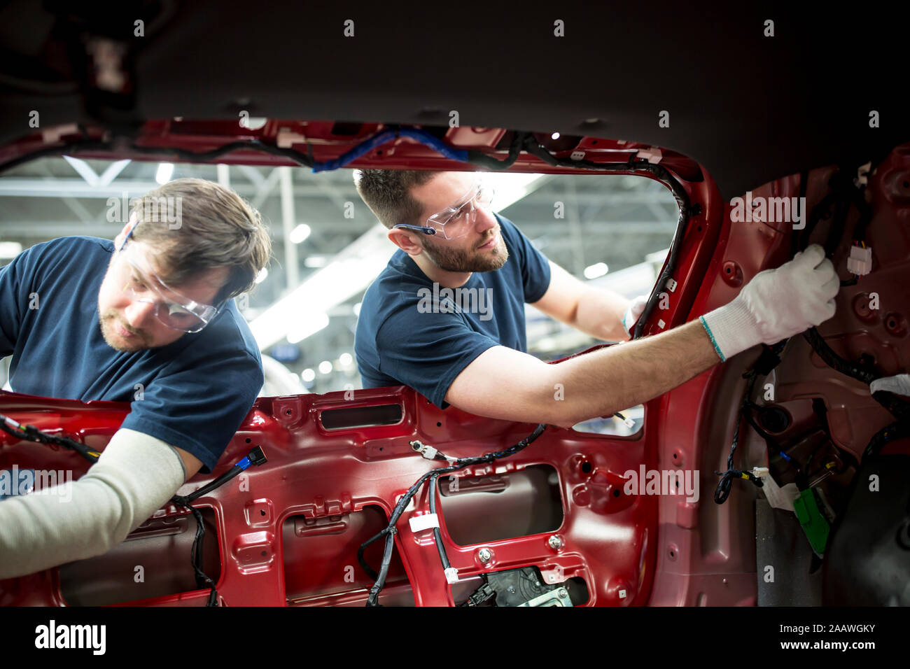 Due colleghi lavorano a carrozzeria nella moderna fabbrica di automobili Foto Stock