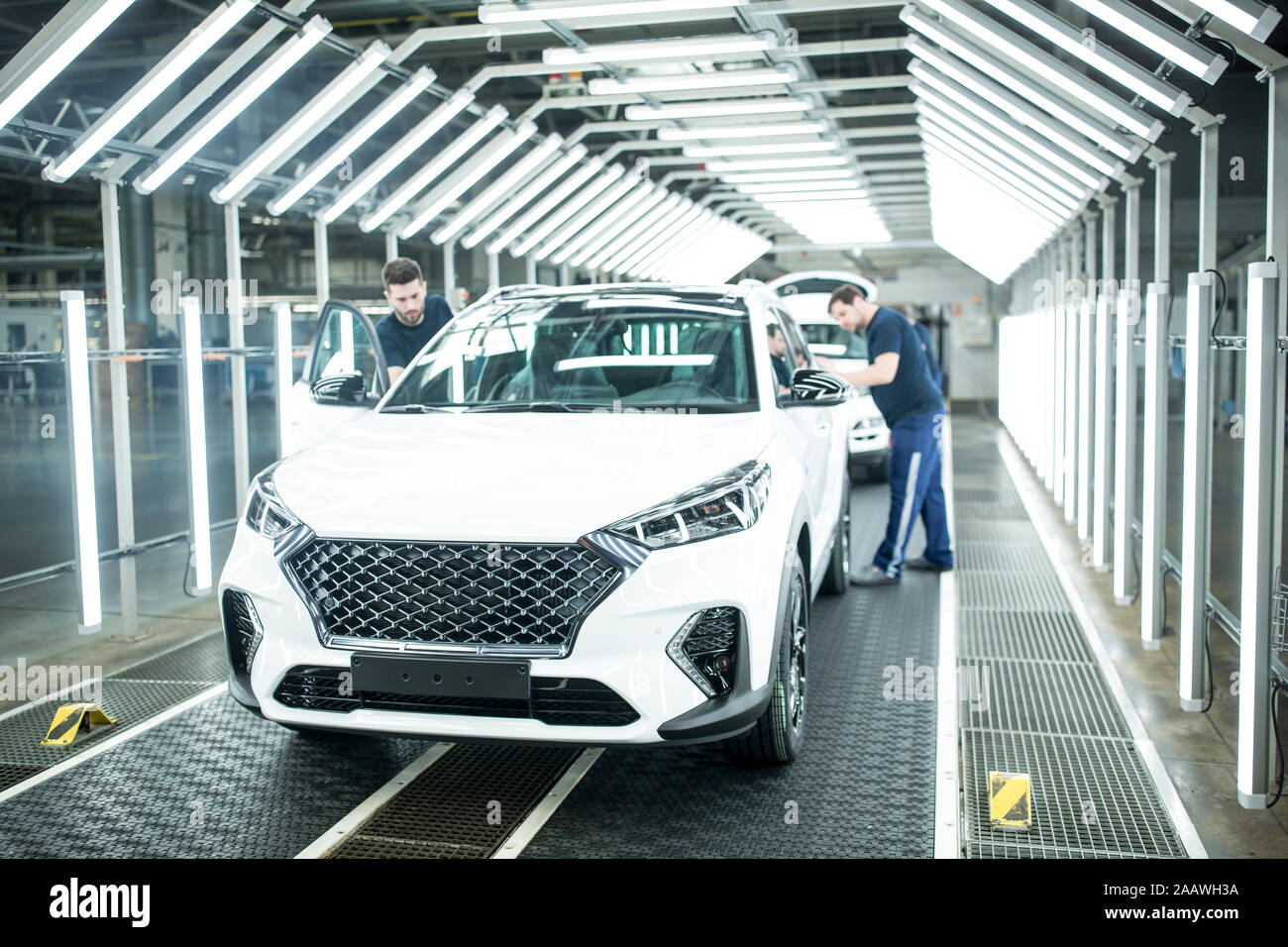 Due colleghi impegnati nella moderna fabbrica di automobili Foto Stock