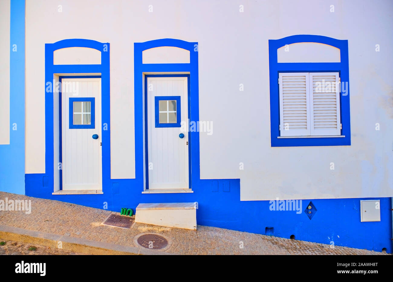 Il Portogallo, Algarve, Arrifana, coppia di porte di entrata di pulire la casa bianca e la Casa azzurra Foto Stock