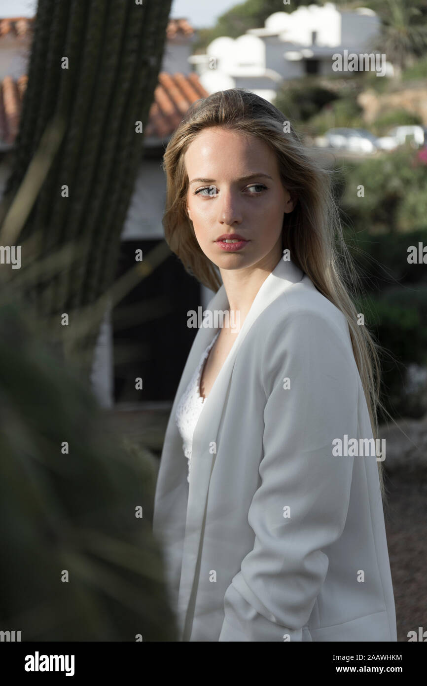 Ritratto di giovane donna bionda indossare tuta bianca coat, Spagna Foto Stock