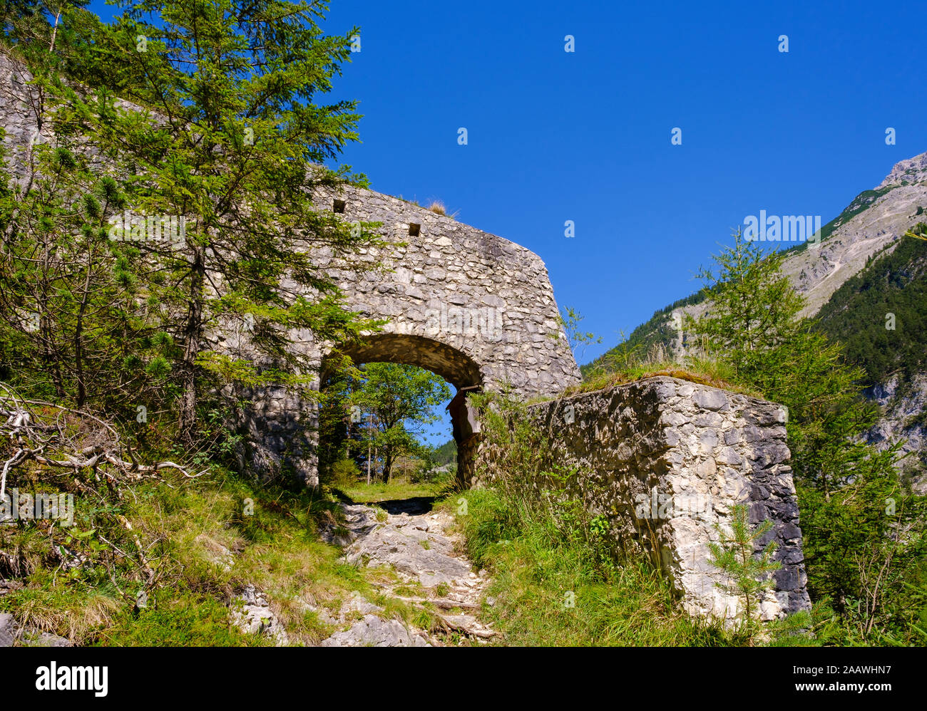 Gate nel muro difensivo di Porta Claudia contro il cielo blu e chiaro a Scharnitz, Tirolo, Austria Foto Stock