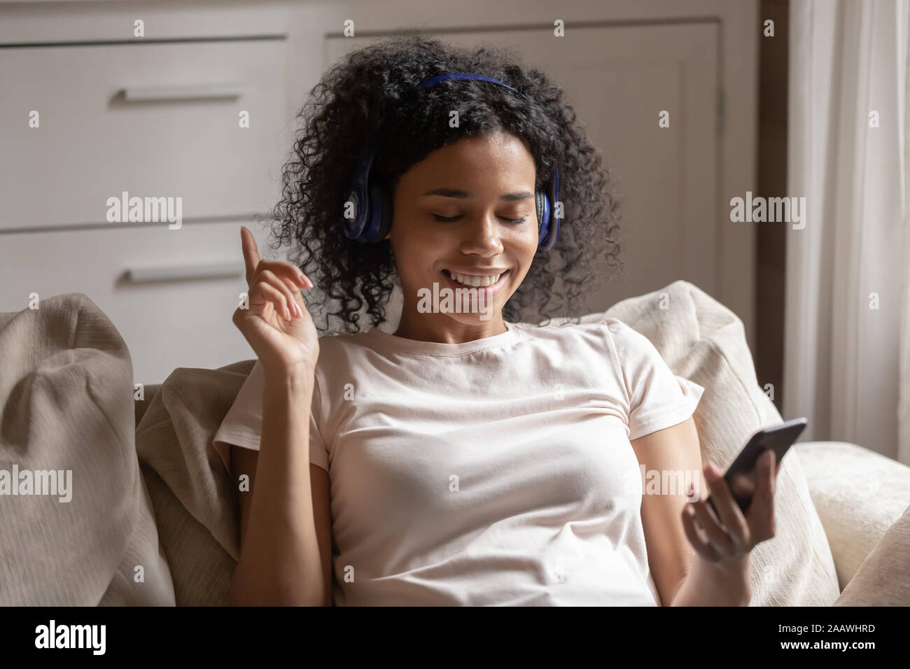 African American donna ascoltare musica con le cuffie Foto Stock