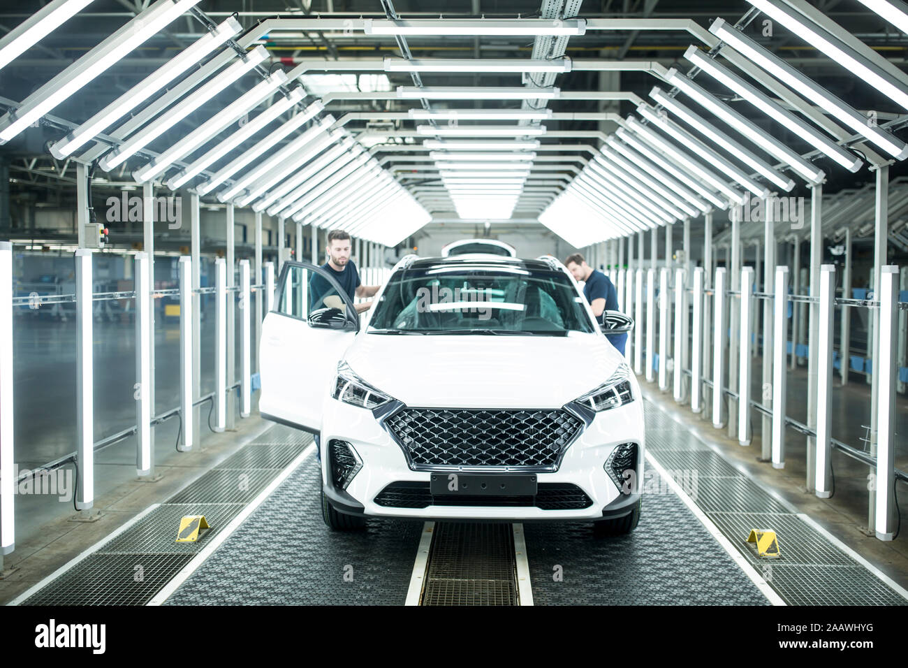 Due colleghi impegnati nella moderna fabbrica di automobili Foto Stock