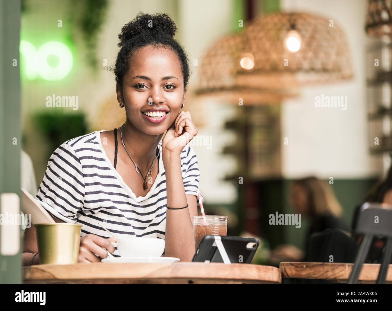 Ritratto di sorridente giovane donna in un cafe Foto Stock