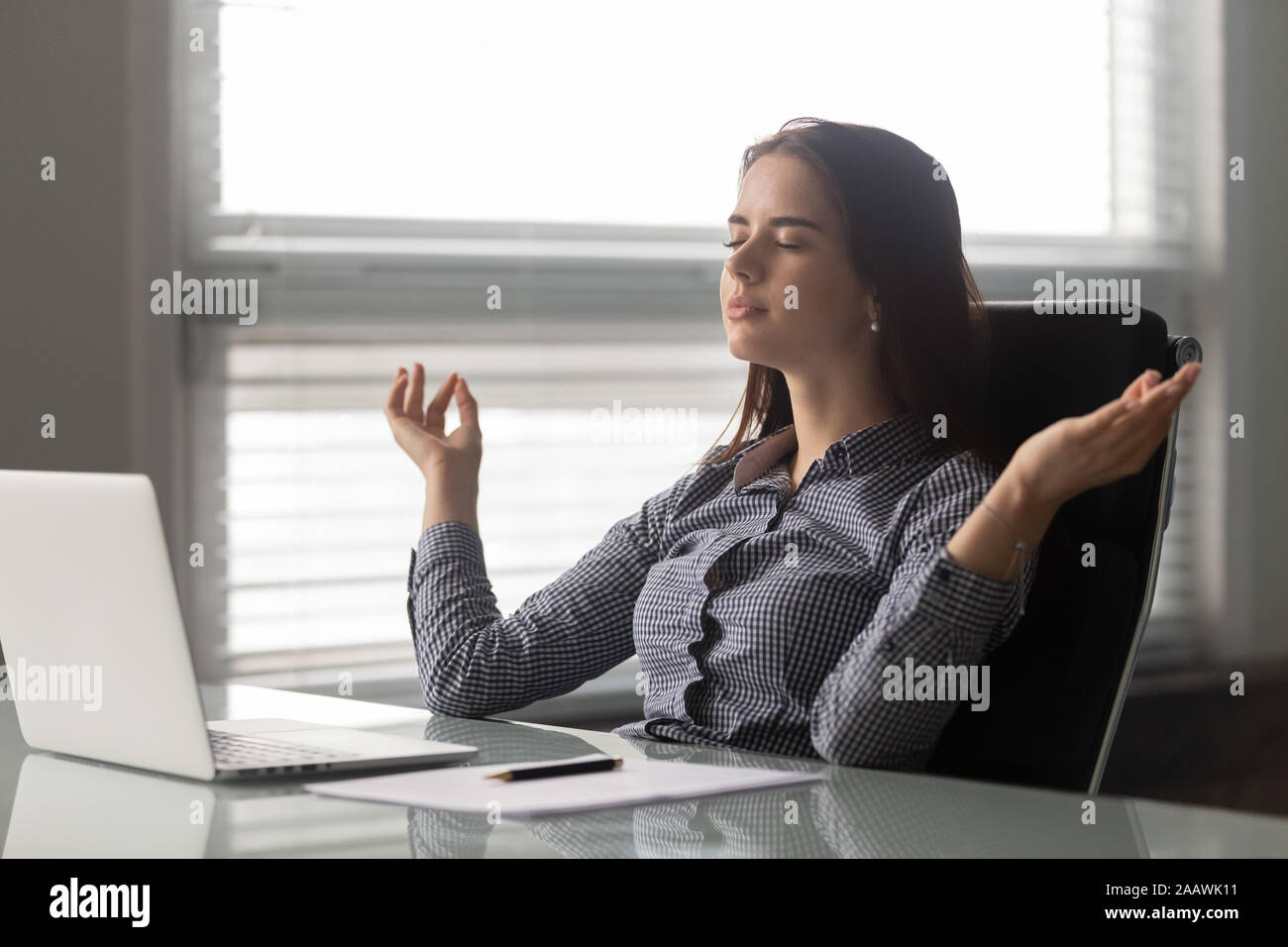 Calma femmina dipendente ufficio meditando al lavoro Foto Stock