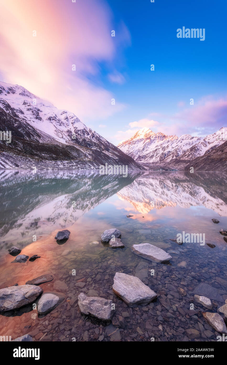 Nuova Zelanda, Isola del Sud, spiaggia rocciosa di Hooker Lago con Mount Cook e Hooker ghiacciaio in background Foto Stock