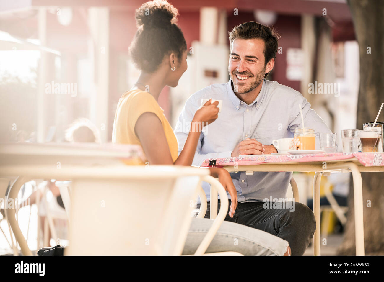Felice coppia giovane socializzare in un cafe' all'aperto Foto Stock