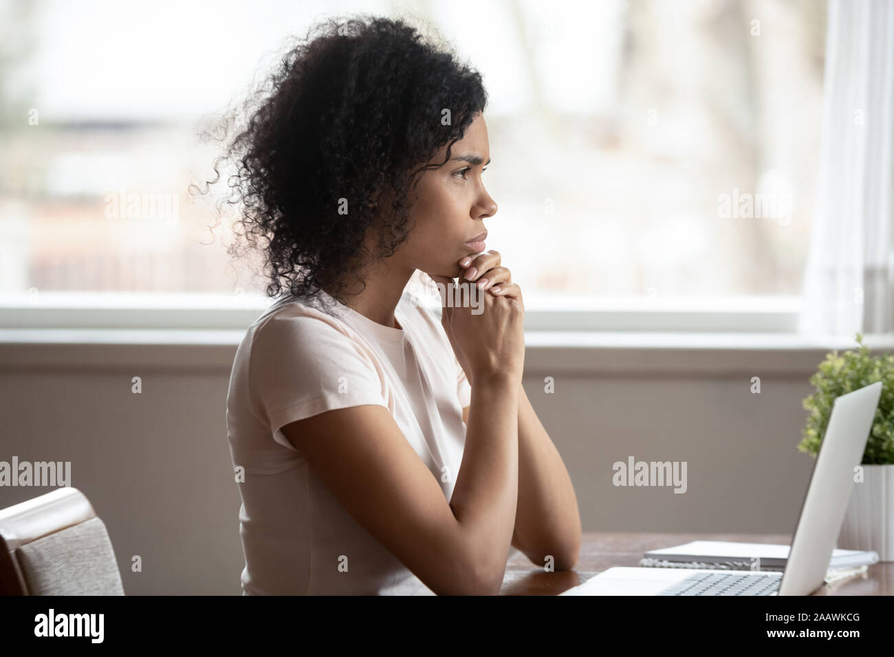 Malinconici americano africano donna guarda nel pensiero di distanza Foto Stock