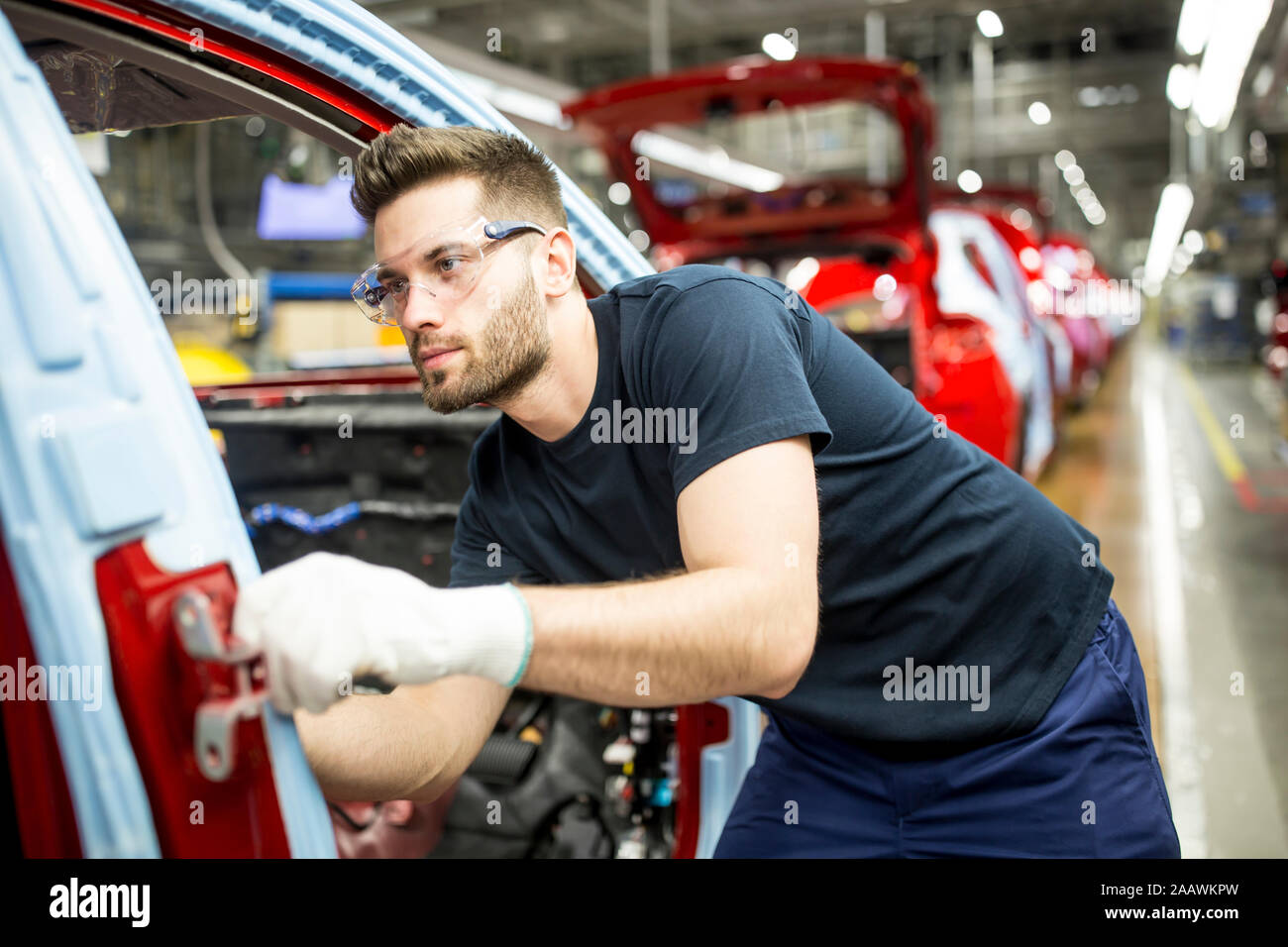 Uomo che lavora nella moderna fabbrica di automobili Foto Stock