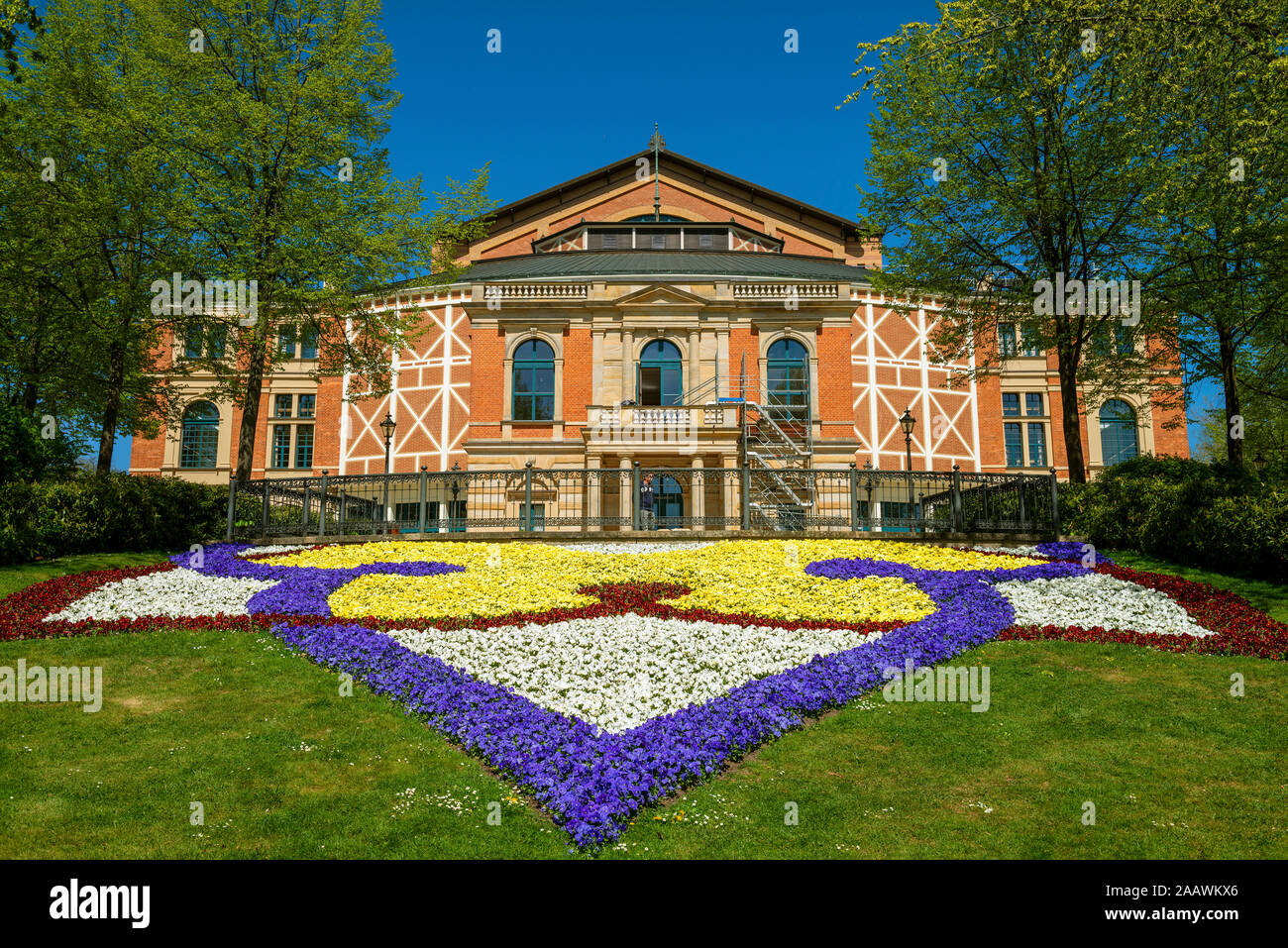 Fiori colorati nella parte anteriore di Bayreuth Festspielhaus durante la giornata di sole, Bayreuth, Germania Foto Stock