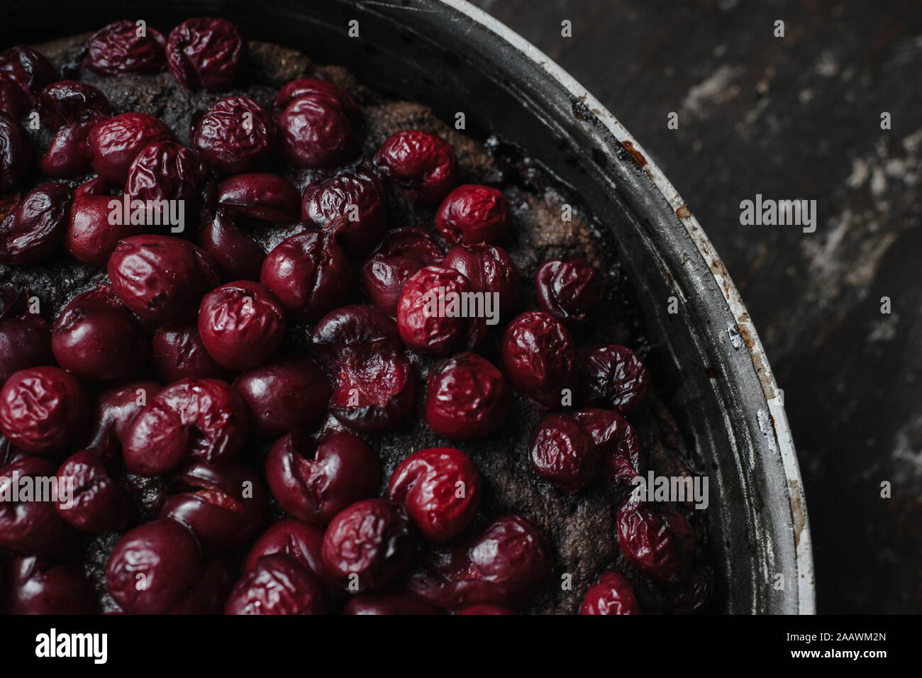 Close-up di brownie torta guarnita con ciliegie nel contenitore sul tavolo Foto Stock