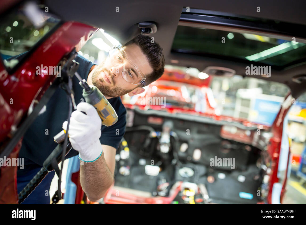 Uomo che lavora alla carrozzeria in una moderna fabbrica di automobili Foto Stock
