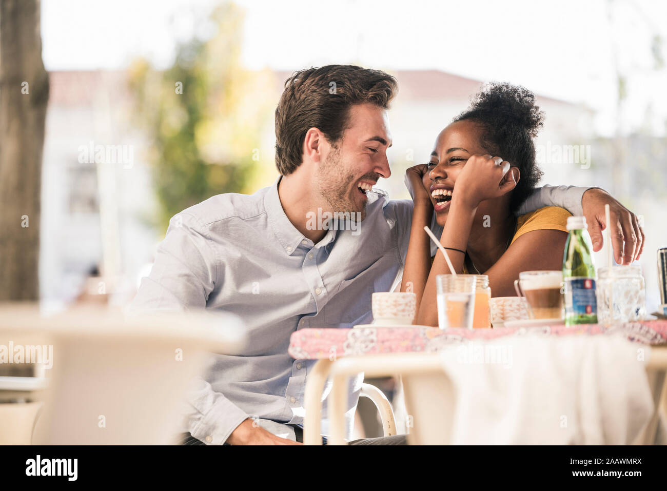 Ridendo coppia giovane a un cafe' all'aperto Foto Stock