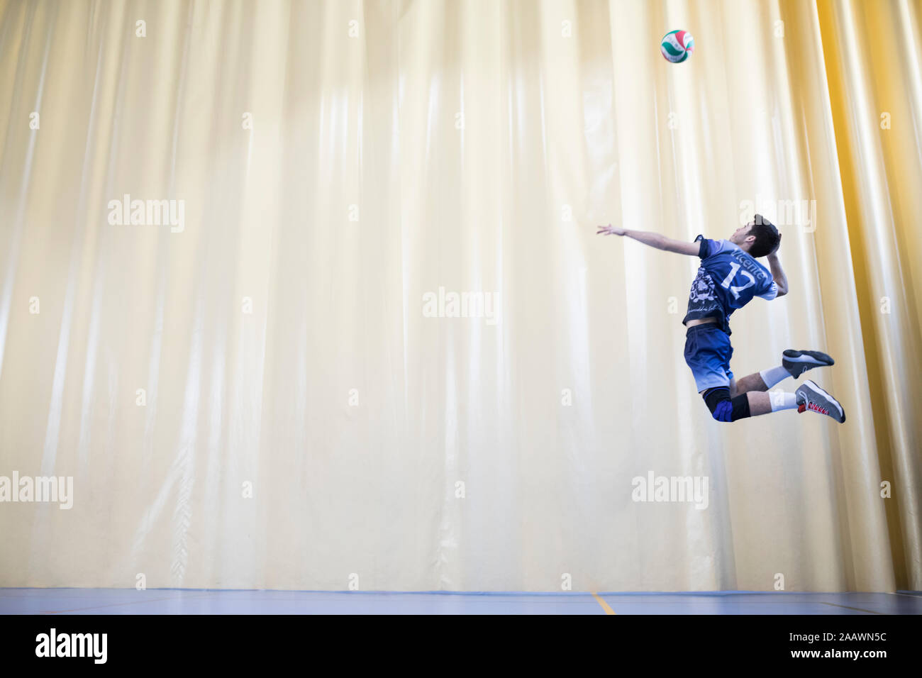 L'uomo jumping durante una partita di pallavolo per avviare un gioco Foto Stock