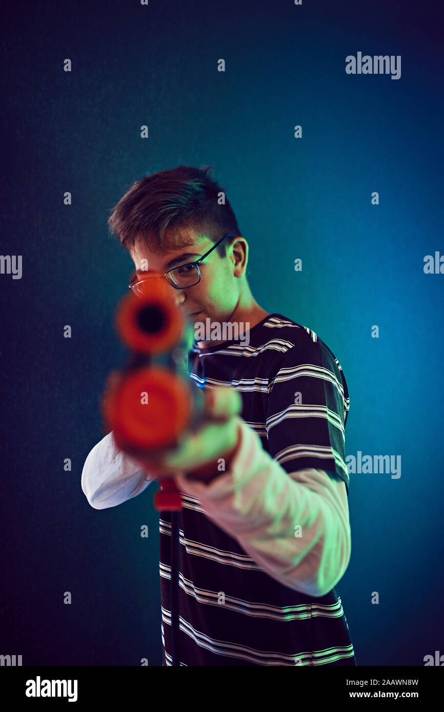 Ragazzo adolescente tiro con la pistola in una sala giochi Foto Stock