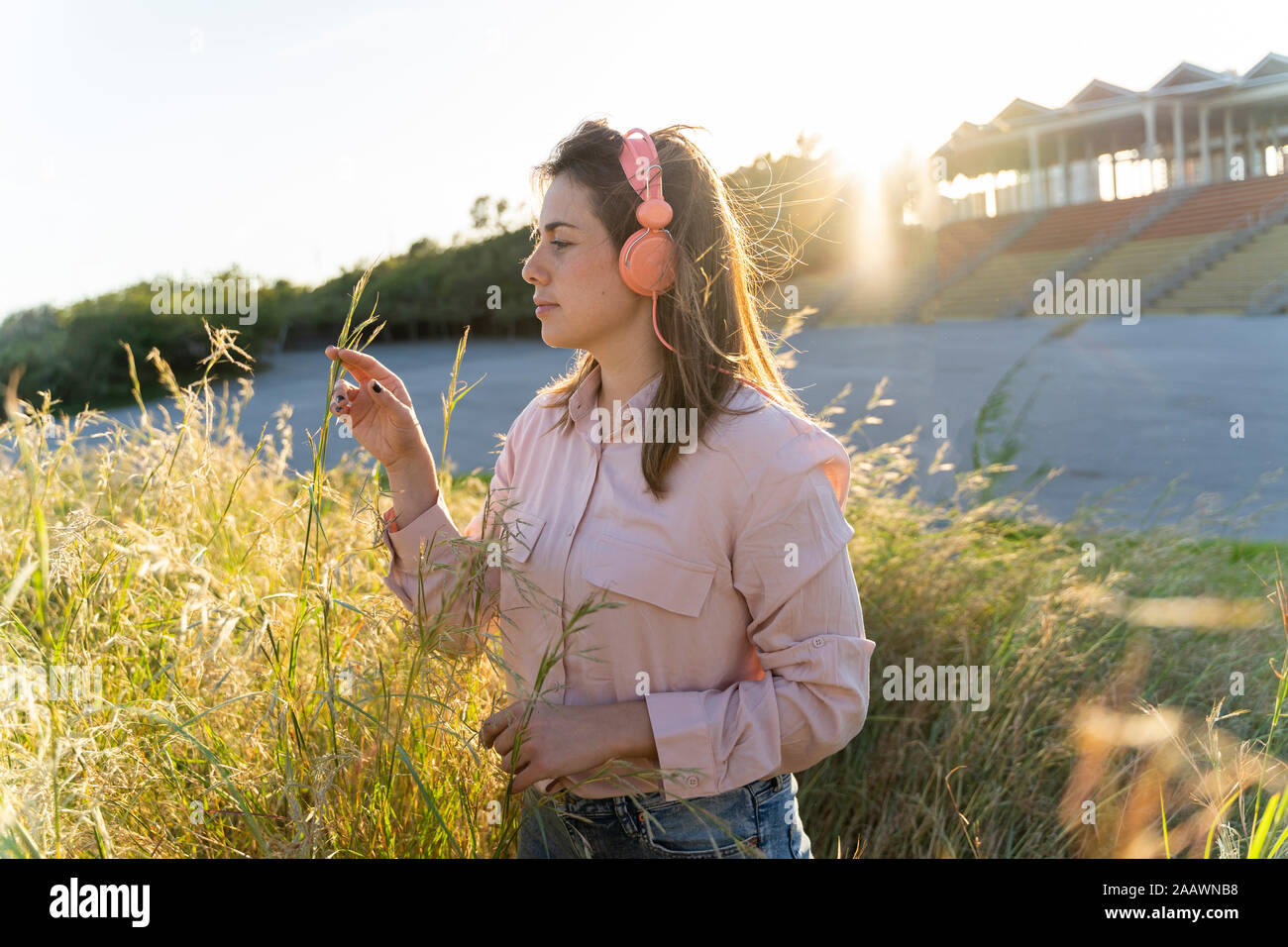 Giovane donna ascoltando musica con le cuffie all'aperto Foto Stock