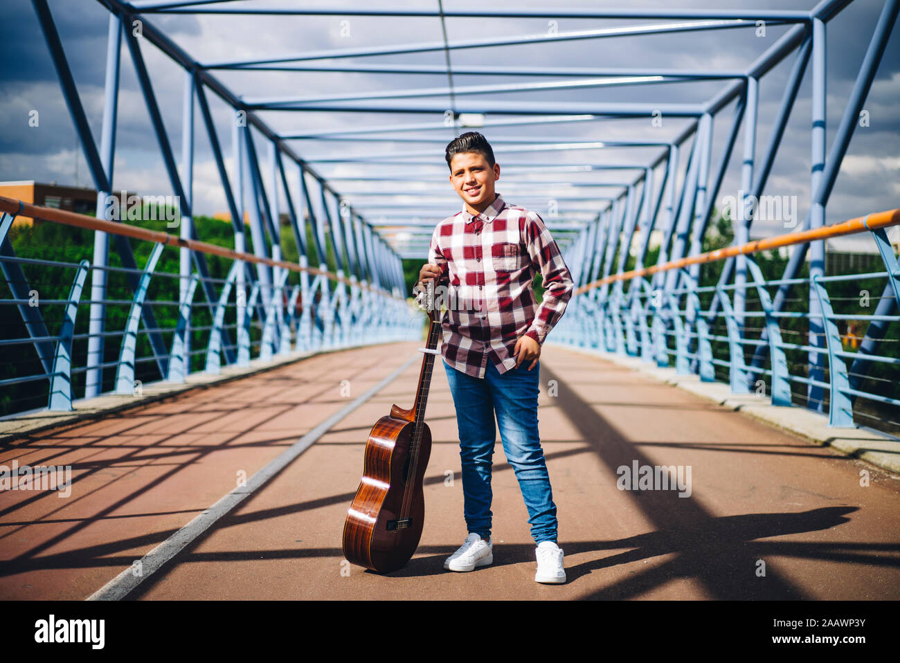 Gypsy ragazzo con la chitarra su un ponte Foto Stock