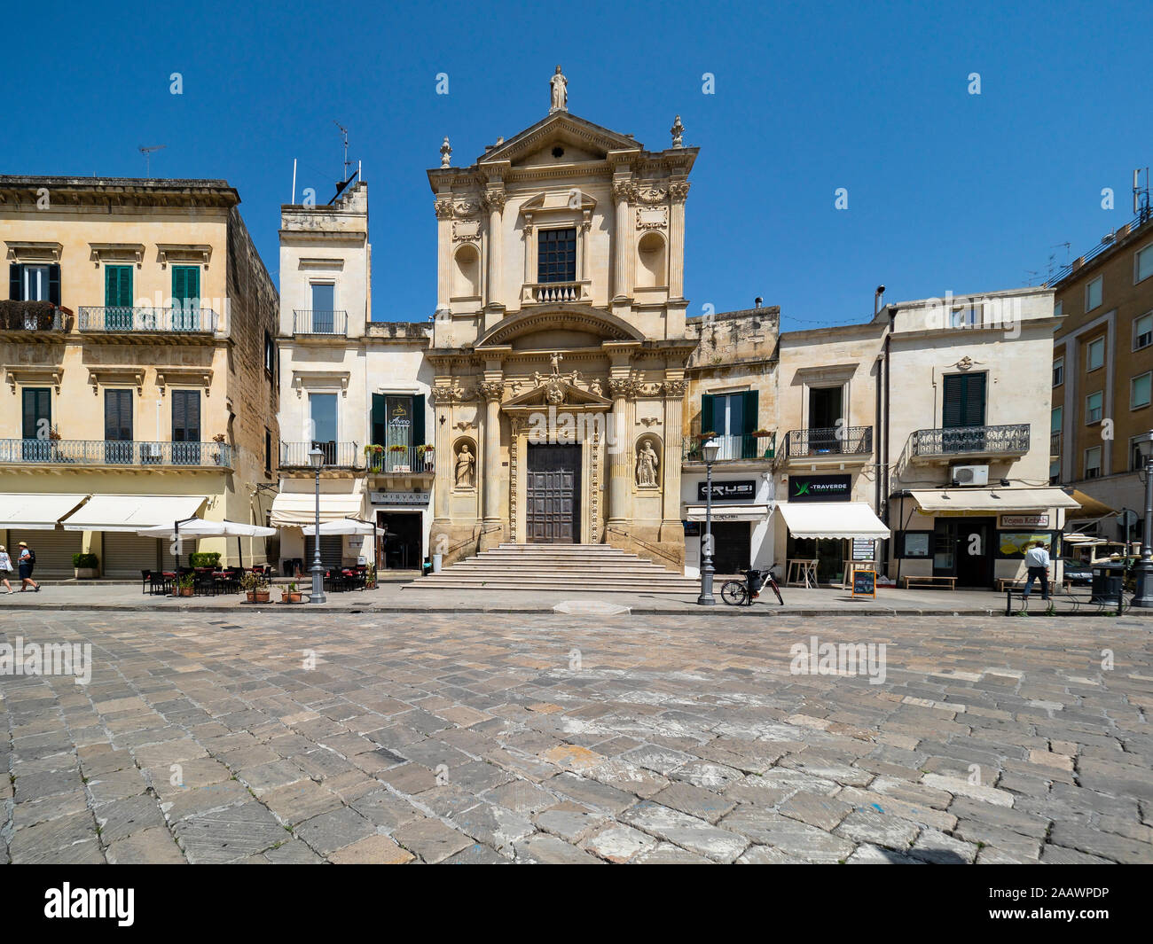 Vista della vecchia chiesa ed edifici contro il cielo blu e chiaro in Altstadt, Lecce, Italia Foto Stock